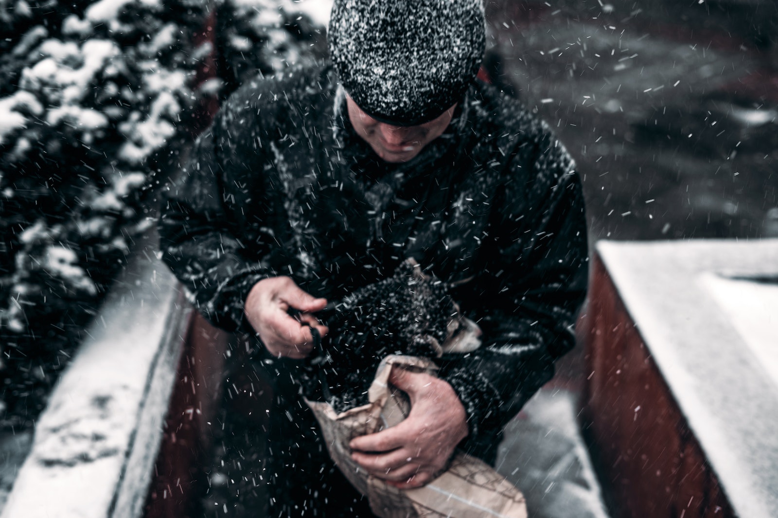 Unrecognizable man with puppy walking on snowy street